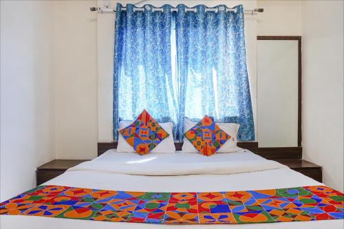 浦那FabHotel Gokul Lodge的一间卧室设有一张大床和窗户