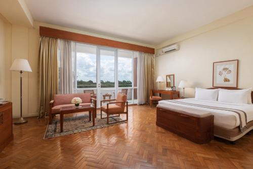 仰光茵雅湖酒店的酒店客房,配有一张床、一张桌子和椅子