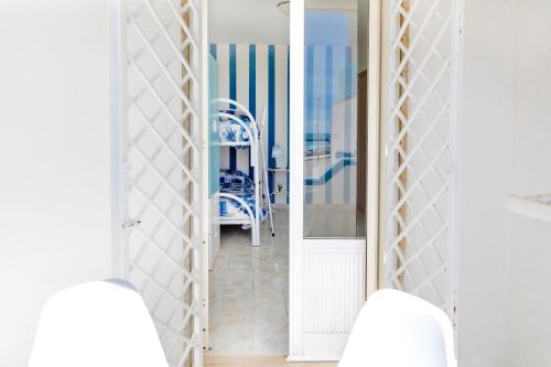 托雷莫泽Casa Tridente - Meravigliosa villa sul mare的走廊上,房间里摆放着蓝色椅子