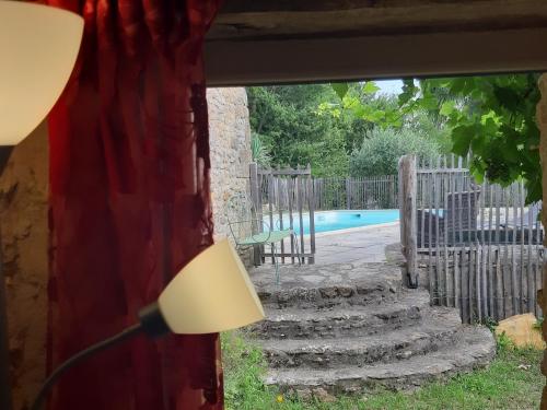 蒙蒂尼亚克Le Chai, gîte de charme avec piscine的带窗户的房间,带一盏灯和一个游泳池