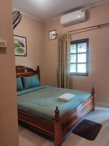 巴色Erawan Guesthouse的一间卧室设有一张床和一个窗口