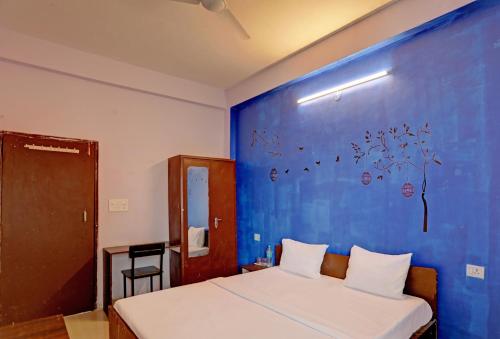 博帕尔Hotel Sambodhi Palace的一间设有一张蓝色墙壁的床的房间