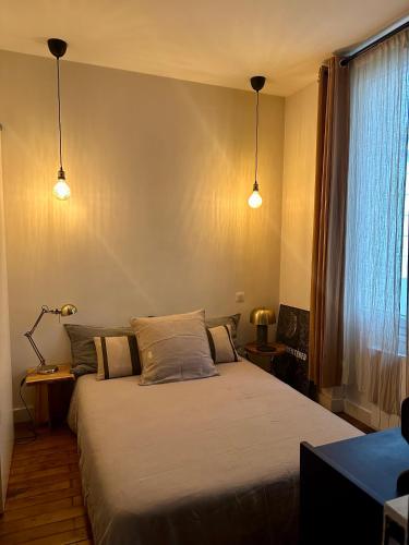 巴黎Appartement Cosy Paris Montmartre的一间带两张床和两盏灯的卧室