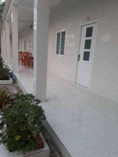 富国Nhà Nghỉ Tốt Hơn的白色走廊,有门,有植物