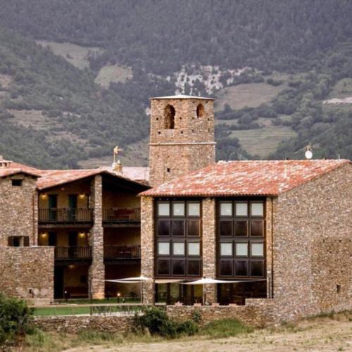 ToloríuLA HOSTERIA DE TOLORIU, el alt Urgell的一座大型砖砌建筑,上面有塔楼