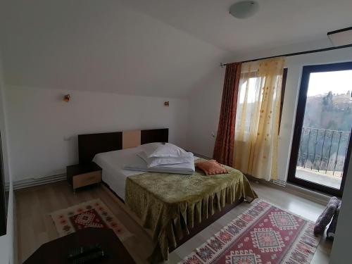 佩什泰拉加洛菲塔岭酒店的一间卧室设有一张床和一个大窗户