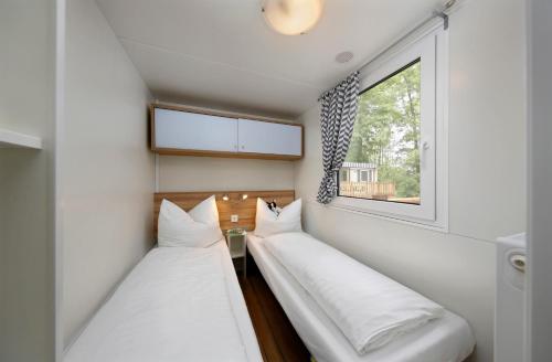 马尔格莱特德玛Albatross Mobile Homes on Camping El Pla de Mar的小型客房 - 带2张床和窗户
