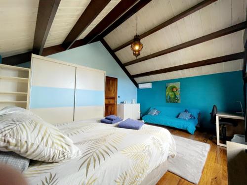圣皮埃尔Villa Hermès Chambre bleue océan的一间卧室设有两张床和蓝色的墙壁