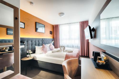 多特蒙德家园酒店的一间酒店客房,配有一张床和一台电视