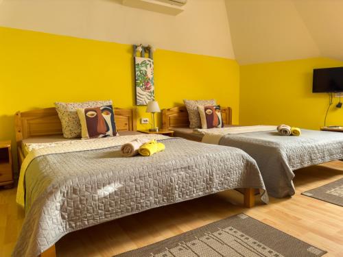 赫维兹泽拉塔普拉哈别墅酒店的黄色墙壁客房的两张床