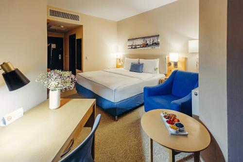 乌斯季卡缅诺戈尔斯克厄斯克门塔罗斯德德曼酒店的酒店客房,配有一张床和一张蓝色椅子