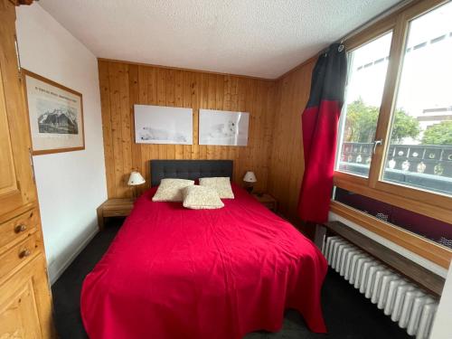 夏蒙尼-勃朗峰Andro的一间卧室配有红色的床和两个枕头