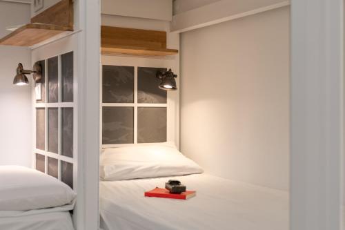 巴塞罗那格雷西亚旅舍的一间卧室设有两张床和窗户。