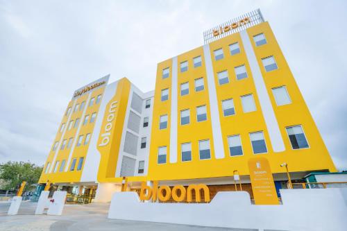 古尔冈Bloom Hotel - Medicity Gurugram, Near Medanta Hospital的黄色的建筑,前面有标志