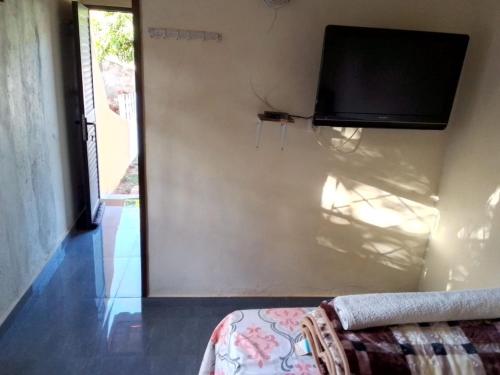 希莫尤Recanto do Meu Tio的一间带电视和沙发的墙壁的房间