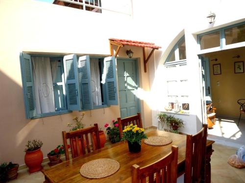 罗德镇Casa Antica的一间带桌椅和蓝色百叶窗的用餐室