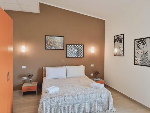 伊索拉迪卡波里祖托Agri B&B Terre Joniche的卧室配有一张带两张桌子的床,墙上有两张照片