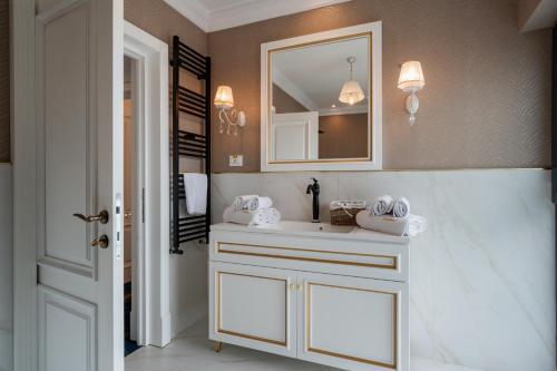 拉姆尼库沃尔恰Hotel NOBLESSE Boutique&Spa的浴室设有白色水槽和镜子