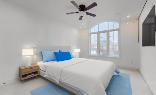布兰普顿Luxurious Stay in the Heart of Community的白色卧室配有床和吊扇