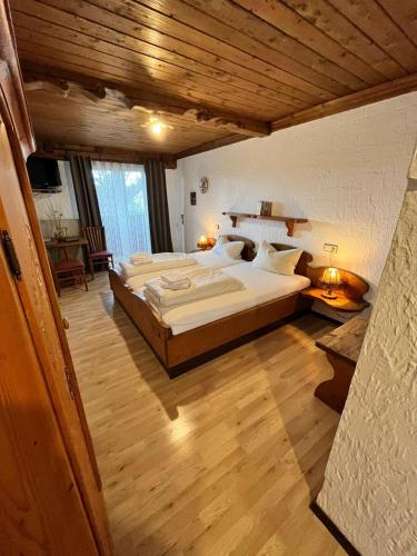 HohenfurchHotel Negele的一间设有两张床和木制天花板的大卧室