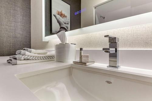 斯波坎Cambria Hotel Spokane Airport的浴室设有白色水槽和镜子