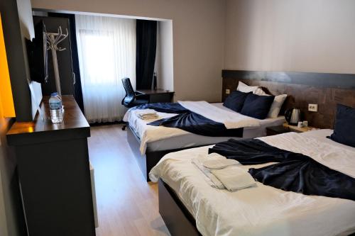 埃尔祖鲁姆Atlas Otel的酒店客房设有三张床和一张书桌
