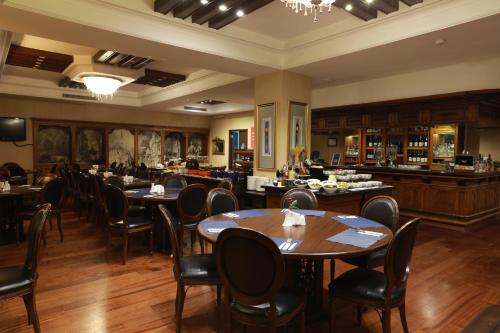 伊兹密尔伊兹密尔安莫酒店的一间带桌椅的餐厅和一间酒吧