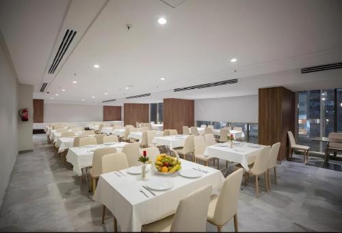 麦加فندق ماسة المشاعر الفندقية的用餐室配有白色的桌子和白色的椅子
