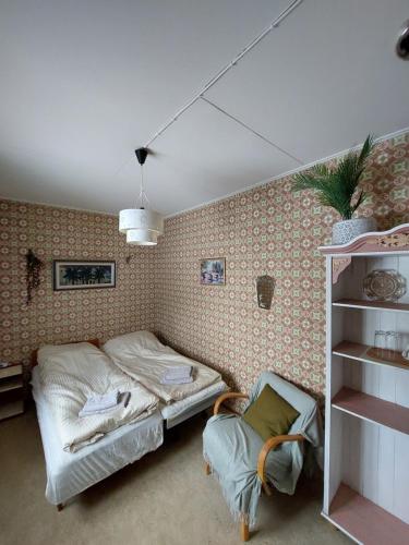 帕亚拉Private Room in Pink House的一间卧室配有一张床和一把椅子