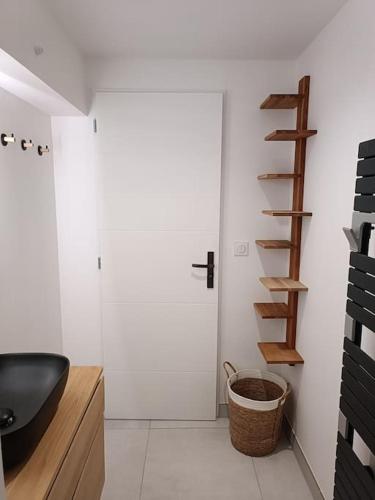 阿尔桑雷Maison de centre-ville Ars en Ré的一间带黑色水槽和木制楼梯的浴室