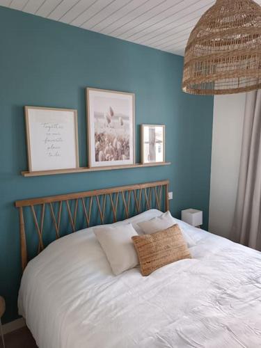 阿尔桑雷Maison de centre-ville Ars en Ré的一间卧室配有一张蓝色墙壁的床
