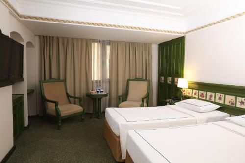 伊兹密尔伊兹密尔安莫酒店的酒店客房,配有两张床和两把椅子