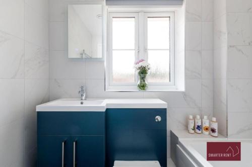 吉尔福德Guildford - 3 Bedroom Home - Driveway & Garden的一间带蓝色水槽和窗户的浴室
