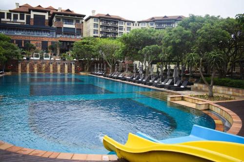 巴利托Resort Retreat, Private Suite, Zimbali Estate的度假村内带椅子的大型游泳池
