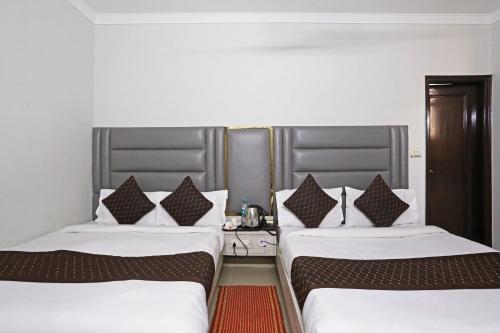 新德里Ratandeep International的两张睡床彼此相邻,位于一个房间里