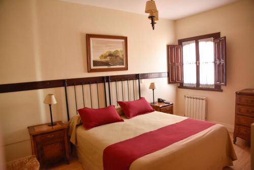 坦迪尔卡萨格兰德旅馆的一间卧室配有一张大床和两个红色枕头