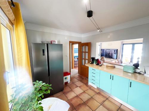 滨海保尔The Yellow House的厨房配有不锈钢冰箱和蓝色橱柜