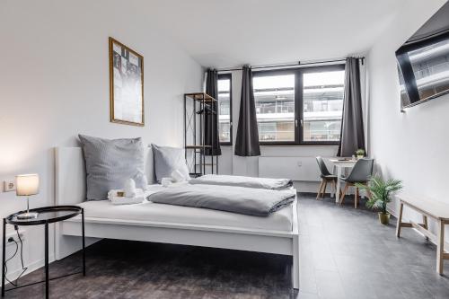 纽伦堡MidTown Nuernberg的白色卧室配有床和桌子