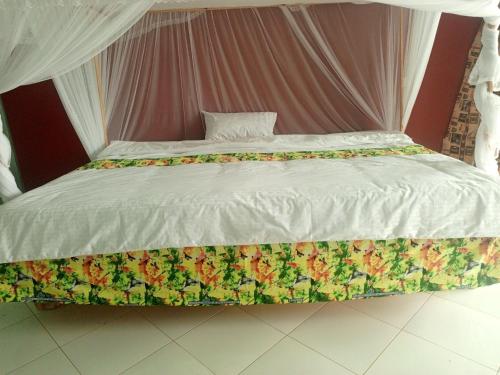 卡巴莱African Tent Resort的一张带白色棉被和鲜花的大床