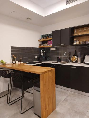 特拉维夫Gindi Tower Apartments TLV的厨房配有黑色橱柜和木桌