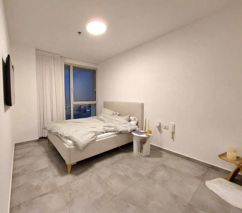 特拉维夫Gindi Tower Apartments TLV的白色的卧室设有床和窗户