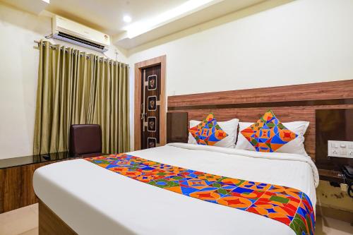 维杰亚瓦达FabHotel Raj Vihar Residency的酒店客房,配有床和电视