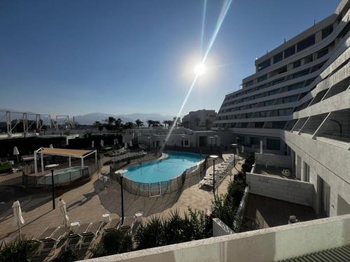 埃拉特Sansa suite SeaSide Sea View dream Apartment的享有游泳池和大楼的景色