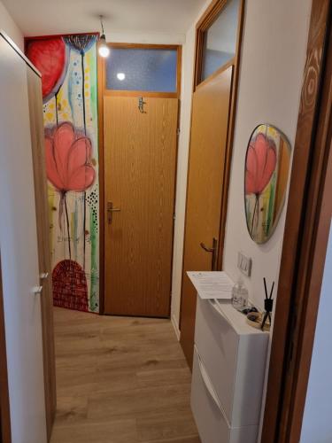 武科瓦尔Studio apartman Šapudl的一间带卫生间的浴室和一扇墙上鲜花的门
