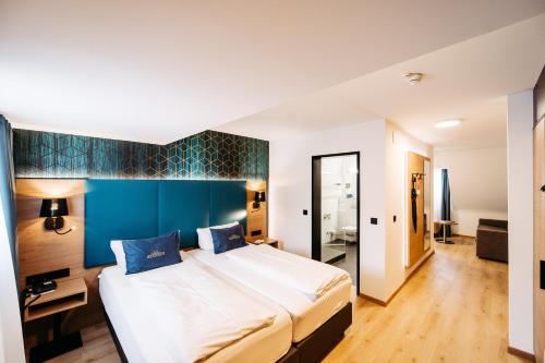 布雷根茨梅斯梅尔酒店的一间卧室设有一张大床和蓝色的墙壁
