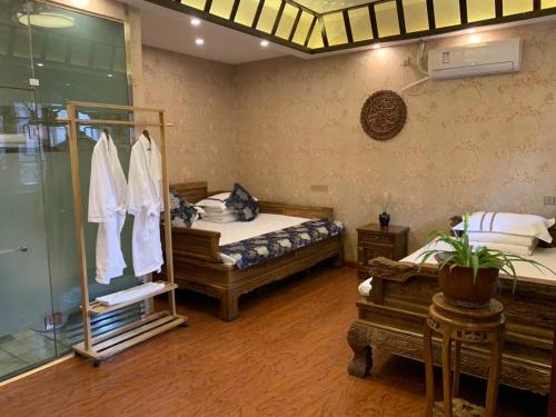平遥Pingyao Hongyuyuan Guesthouse的一间卧室设有两张床和玻璃淋浴间