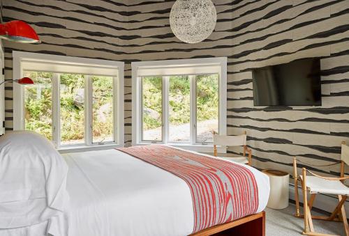 斯托Field Guide Lodge的一间卧室配有一张床和一台平面电视