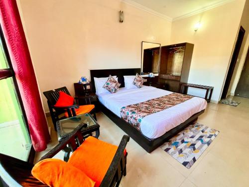 卡兰古特Hotel Shivam Inn - Near Calangute Beach的一间卧室配有一张床和一把椅子