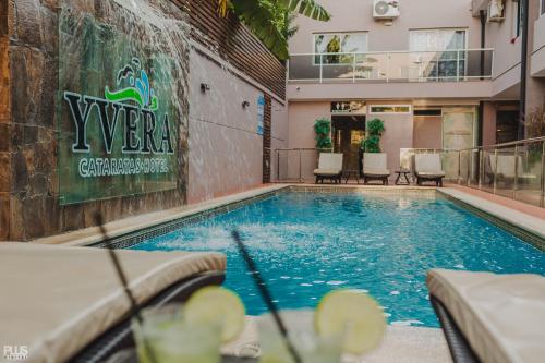 伊瓜苏港伊弗拉卡塔拉塔斯酒店的一座带椅子的游泳池以及一座建筑