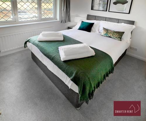 BrookwoodKnaphill, Woking - 2 Bedroom House - Garden and Parking的一间卧室配有一张大床和两个枕头